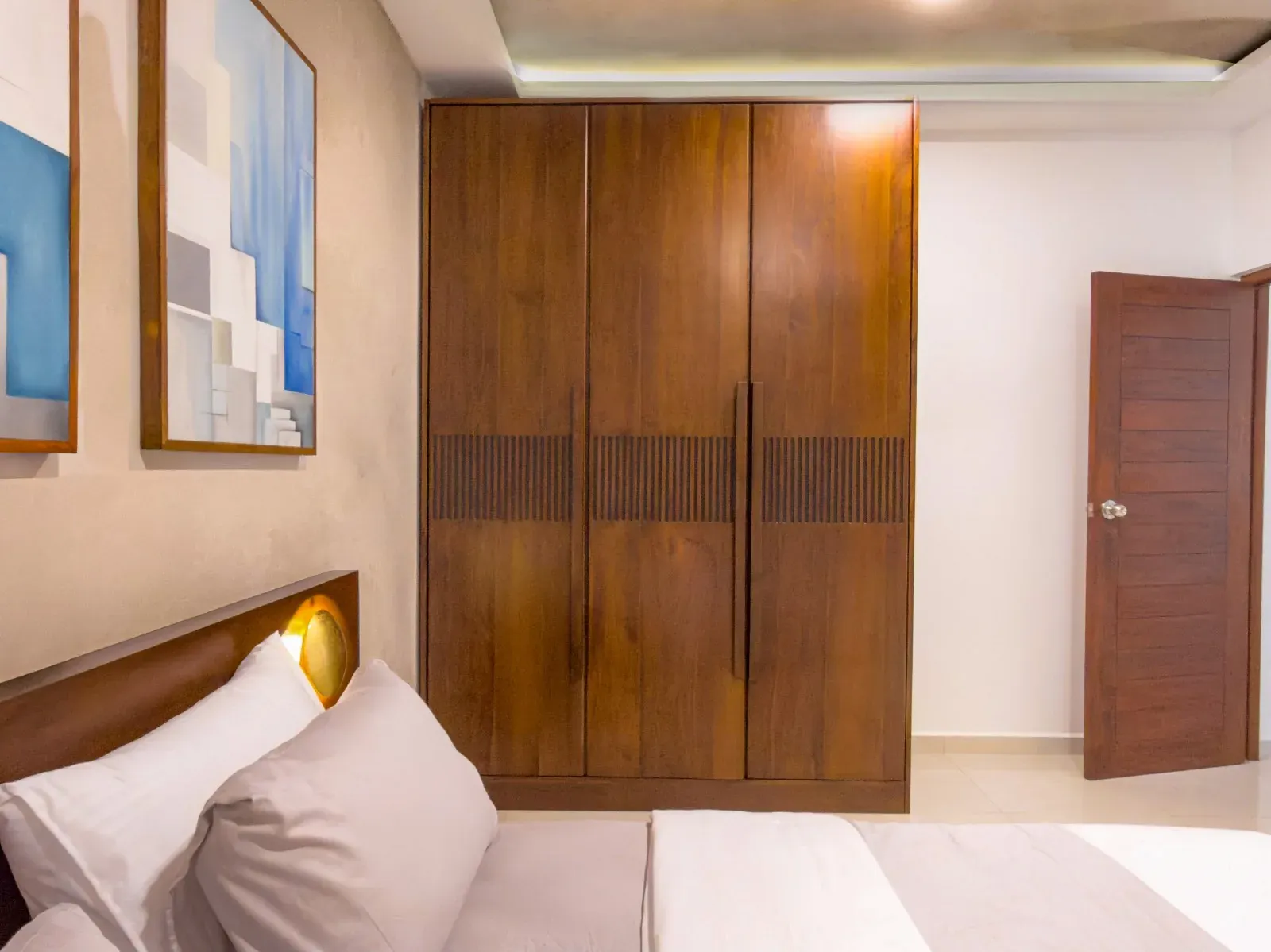 Tall walnut wardrobe with a carved horizontal band across the doors