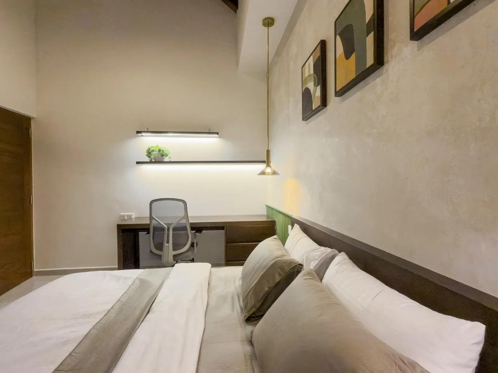 Built-in study desk with a lit shelf beside the bed