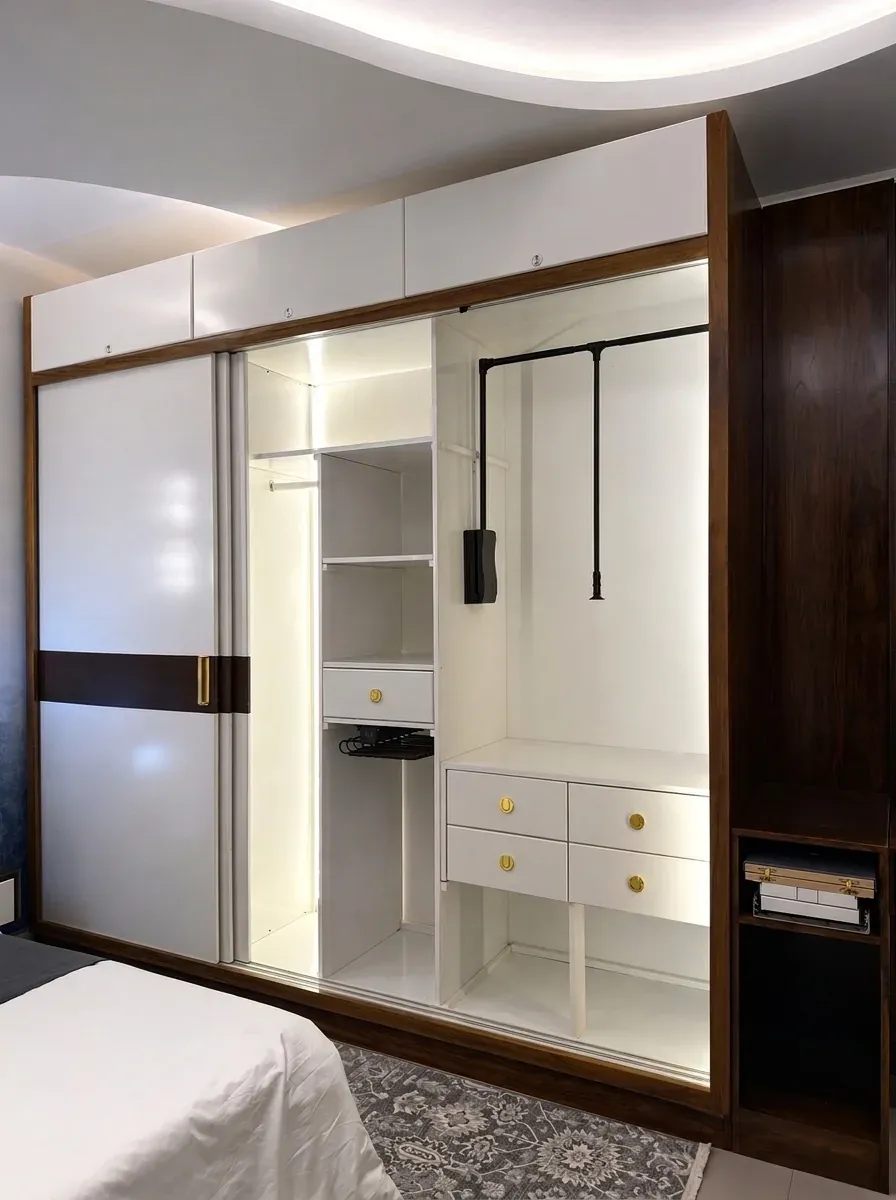 Built-in sliding wardrobe with lit hanging space and white drawers, made by SM Interiors for The Heights apartment in Narahenpita
