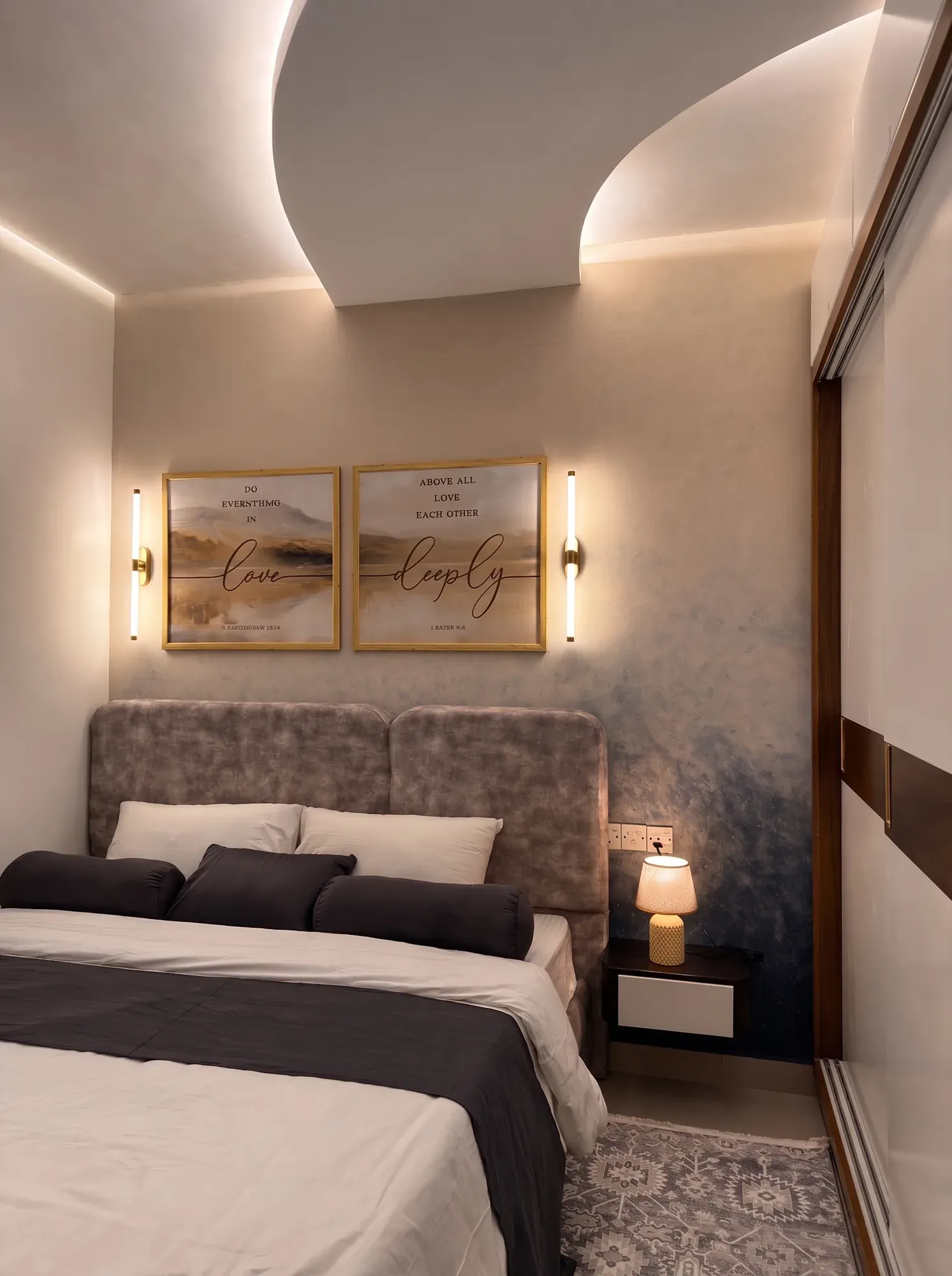 Master bedroom with the curved cove ceiling continuing above a grey velvet headboard